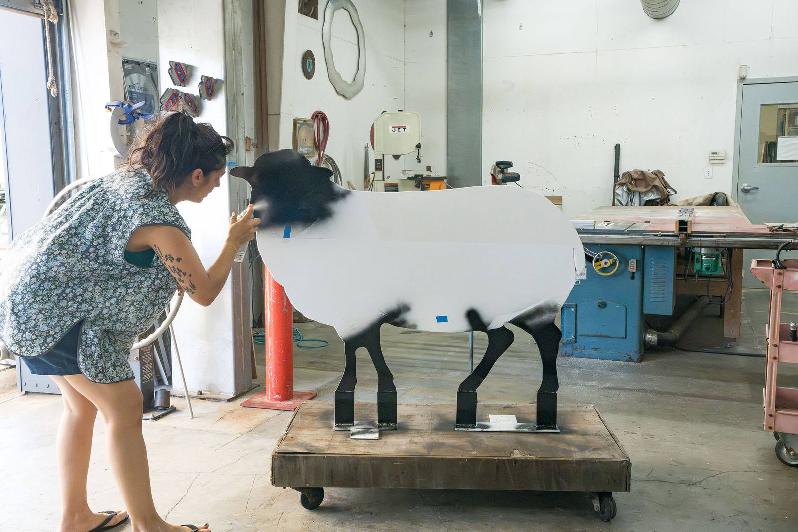 Erika Huether adds the final details to a restored sheep at Gordon Huether’s Napa studio. Each sculpture was sandblasted and refinished with a durable powder coat, according to the center.