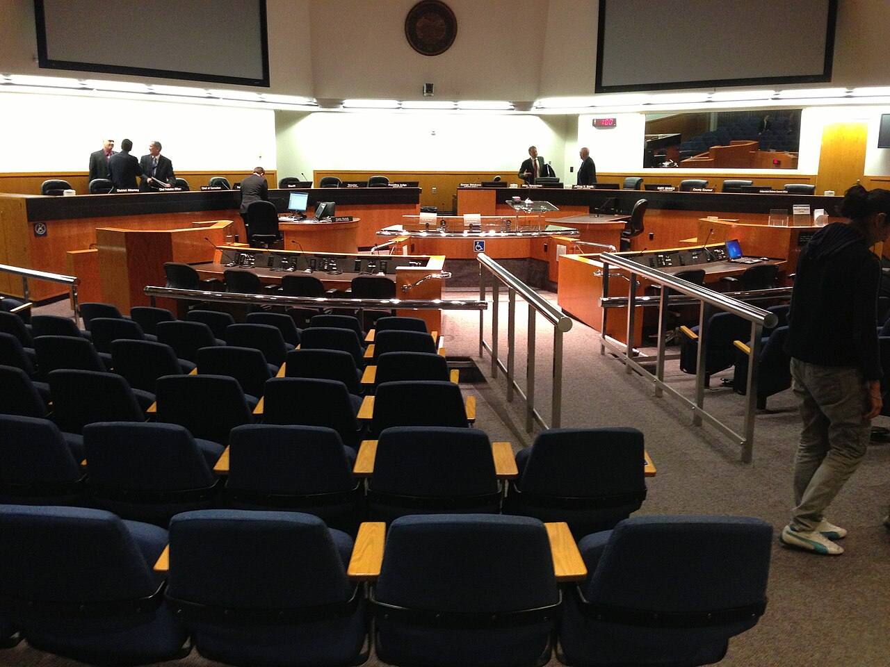 A California board of supervisors chambers; the forum offers remote participation and Spanish interpretation.