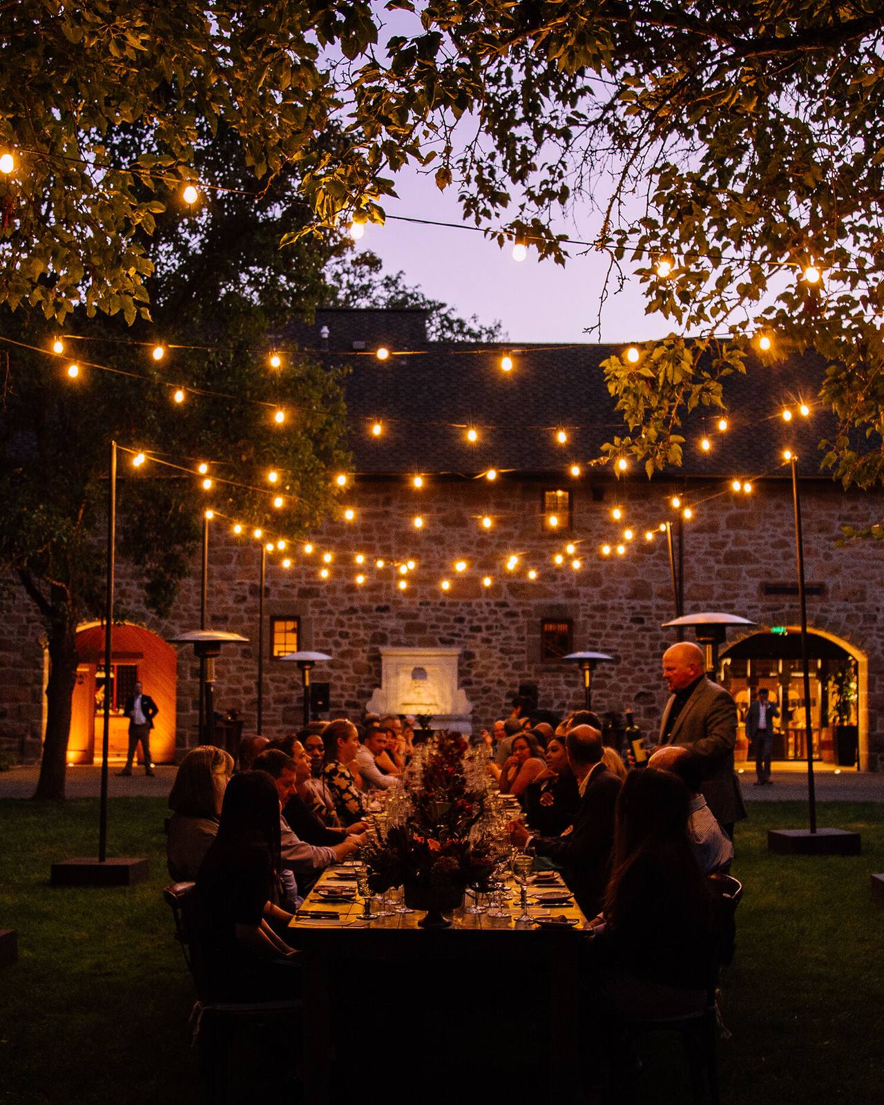 String lights over an outdoor dinner at Freemark Abbey's historic stone winery in St. Helena.