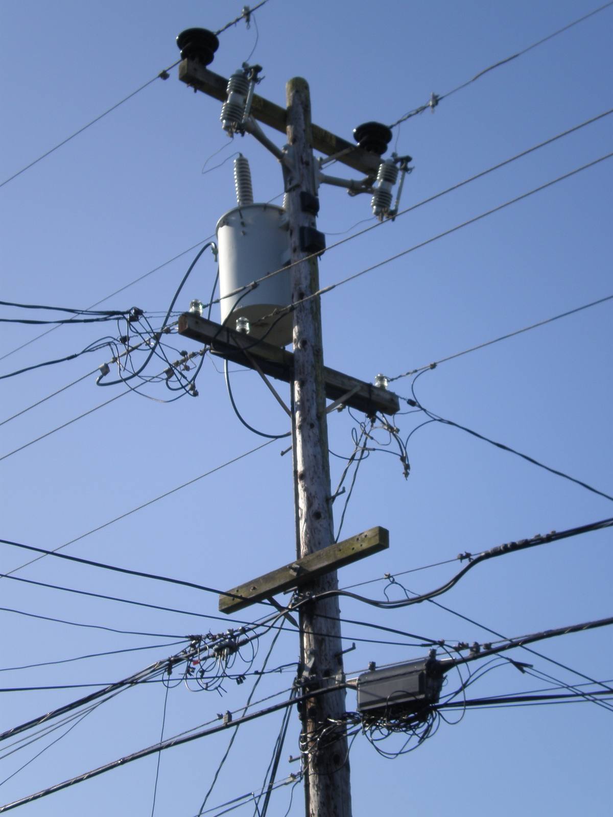 A wooden utility pole with a transformer and bundled distribution lines in South San Francisco. PG&E says precautionary shutoffs reduce the risk of electrical equipment sparking a wildfire in dry, windy conditions.