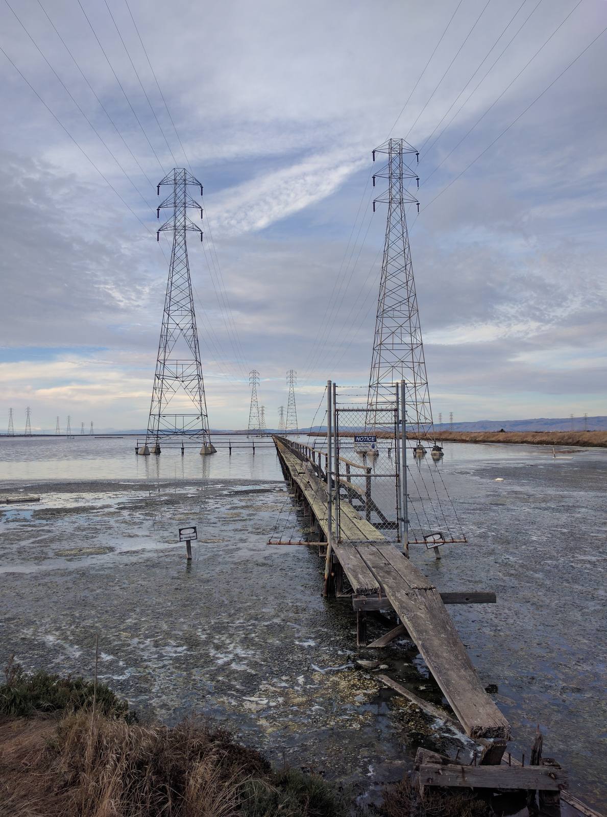 Transmission towers carry high-voltage lines across the San Francisco Bay shallows near Mountain View. If shutoffs proceed, PG&E says it will open community resource centers with water, snacks and device charging.
