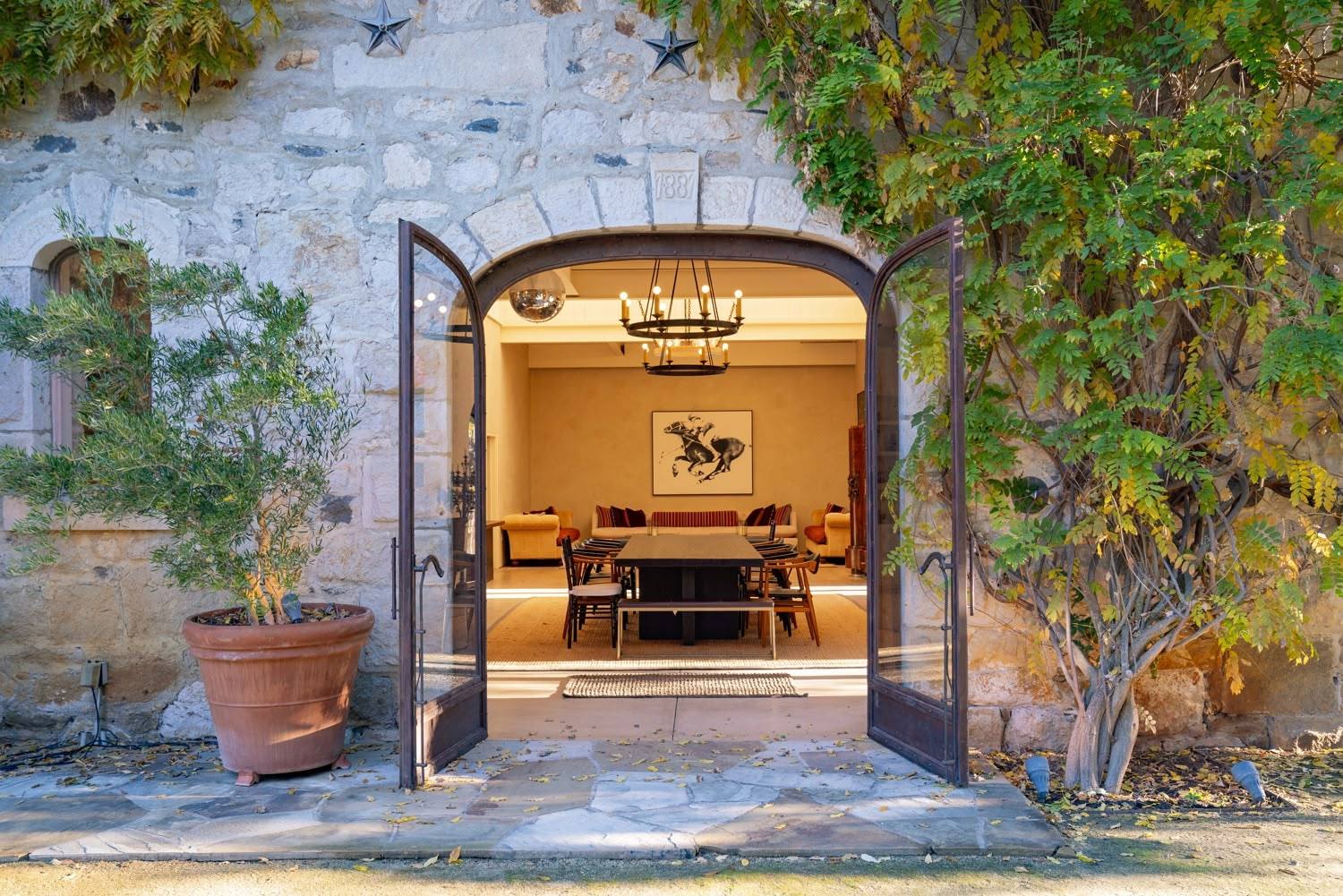 The arched doorway of the 1887 stone building at La Herradura Ranch, the date carved in the keystone above the doors. The 151-acre ranch carries 25.91 acres of vineyard planted in 2020, with a further 47.4 acres described as plantable.
